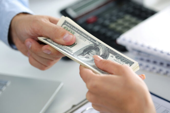Man taking batch of hundred dollar bills. Hands close up