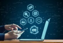 Hand with smartphone next to laptop. KYC concept