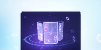 Close up of laptop computer with creative digital blue cards on screen on light background. Online casino, poker and digital gaming