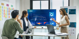 worman leader presenting a financial data and strategies in a modern office with charts and graphs displayed on a large screen