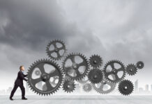 Young determined businessman making gear mechanism move