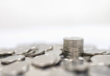 Business, Money, Finance, Security and Saving Concept. Close up of pile and stack of silver coins on white background and copy space.