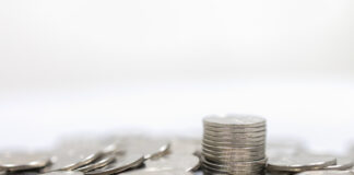 Business, Money, Finance, Security and Saving Concept. Close up of pile and stack of silver coins on white background and copy space.