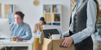 Close-up of young businesswoman packing her things at her workplace
