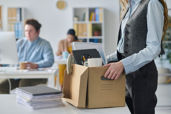 Close-up of young businesswoman packing her things at her workplace