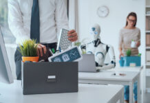 Dismissed business people packing their belongings and leaving the office, a robot is sitting at the desk and working: the impact of AI on jobs