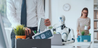 Dismissed business people packing their belongings and leaving the office, a robot is sitting at the desk and working: the impact of AI on jobs