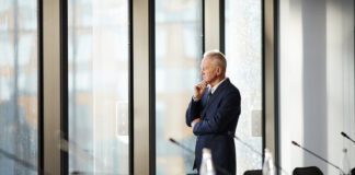 CEO thinking while standing by the window in the office