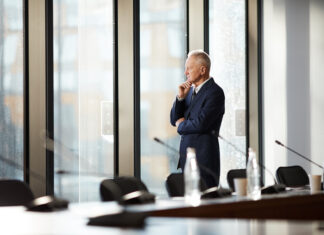 CEO thinking while standing by the window in the office