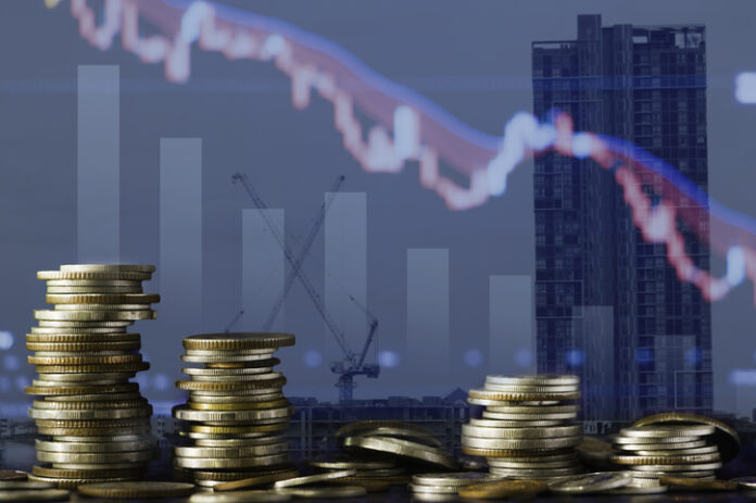 Coins stack and stock market investment graph,concept of business investment, stock future trading , clash and bear market with real estate background.