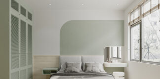 The interior of a bright bedroom features white and green paint on the wall, and green cabinet