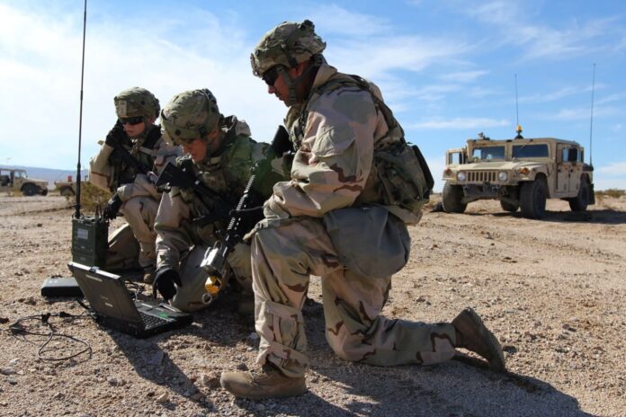 (Left to right) Spc. Ashley Lethrud-Adams, PFC Kleeman Avery, and Sgt. Alexander Lecea, cyberspace operations specialists with the Expeditionary Cyber Support Detachment, 782nd Military Intelligence Battalion (Cyber), provide support to the 1st Cavalry Division at the National Training Center.