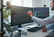 Trading S&P Futures Made Simple: A Step-by-Step Guide for Beginners Young trader is pointing at graphs on computer screen and analyzing data while working in his modern office.