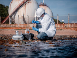 AI Artificial Intelligence for Monitoring Pollutants in Water Scientist wearing safety uniform and glove under working water analysis and water quality by get waste water to check case in laboratory is environment pollution problem