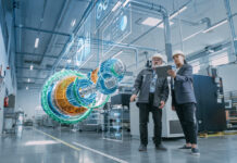 Factory Digitalization: Two Industrial Engineers Use Tablet Computer, Analysing Data about a 3D Model of Green Energy Engine. Industry 4 High-Tech Electronics Facility with Manufacturing Products