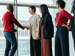 Successful team introduction during a corporate meeting. Diverse professionals engaging in a positive interaction, fostering a collaborative office environment.