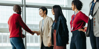 Successful team introduction during a corporate meeting. Diverse professionals engaging in a positive interaction, fostering a collaborative office environment.