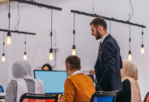 Why Your Gen AI Learning Strategy Will Fail Without Employee Buy-In Manager teaching employees on incorporating AI in workflow