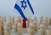 Netanyahu Cabinet’s Complicity in the Gaza Genocide Group of people figurines and small flags of Israel. Red special man to the crowd traitor