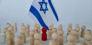 Group of people figurines and small flags of Israel. Red special man to the crowd traitor