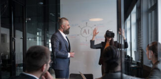 Business professionals in a modern office discussing artificial intelligence strategy. A woman wearing a VR headset gestures while presenting. Concept of innovation, technology, and AI integration.