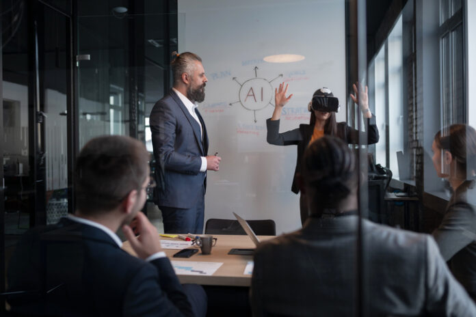 Business professionals in a modern office discussing artificial intelligence strategy. A woman wearing a VR headset gestures while presenting. Concept of innovation, technology, and AI integration.