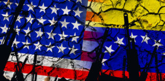 Several automatic rifles raised up on the background of the American Venezuelan flag
