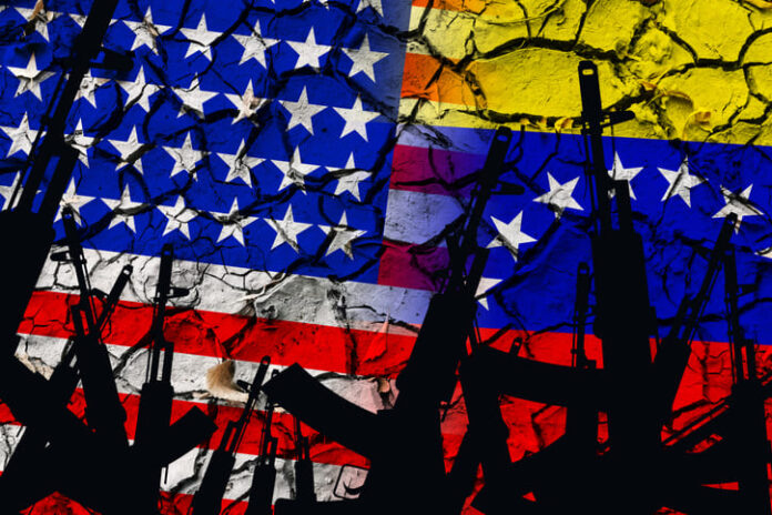 iStock-1280792369 (1) Several automatic rifles raised up on the background of the American Venezuelan flag
