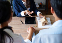From Handshakes to HAL 9000: The Wild Evolution of Digital Real Estate Lending Portrait of a real estate agent or bank officer, the lending department quotes the interest on the loan to the customer to assess the risk of investing in a home