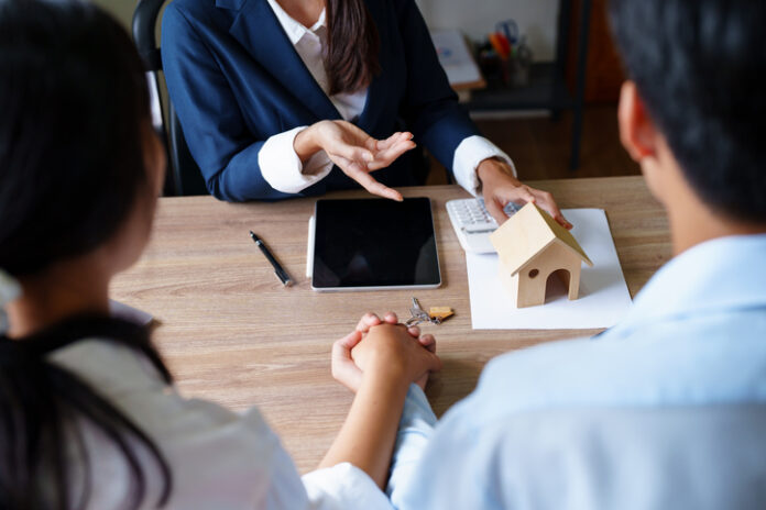 Portrait of a real estate agent or bank officer, the lending department quotes the interest on the loan to the customer to assess the risk of investing in a home