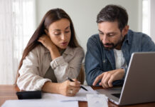 Top 5 High-Inflation Strategies: Investing in Education Funds During High Inflation Wife and husband review financial documents seated at table with laptop, check receipts, discussing invoices, education savings or new rates.
