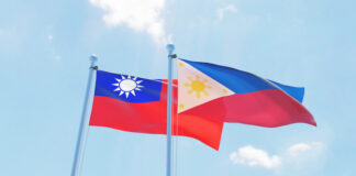 Philippines and Taiwan, two flags waving against blue sky.