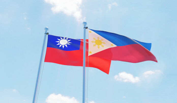 Philippines and Taiwan, two flags waving against blue sky.