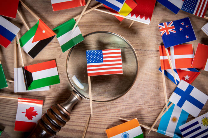 iStock-1303173752 (1) The flag of the United States of America and the magnifying glass. Multipolar International Law