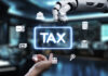 AI in Tax Preparation: What to Automate and Where Human Tax Experts Still Matter A futuristic robotic hand reaches out to interact with digital tax icons, symbolizing the merger of technology and finance in a modern workspace. AI in Tax Preparation concept