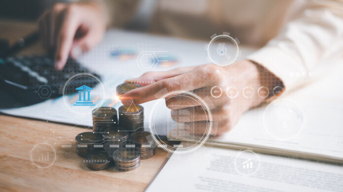 accountant putting money coins and calculate the numbers in the company's financial documents with a calculator, Planning to assess and review the budget, concept of finance and investment Companies Today Remain Profitable Without Hiking Prices