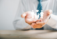 Safety for families, Businessman protective gesture complements young family silhouette. Health and house insurance icons symbolize protection, supporting the concept of family life insurance.