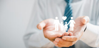 Safety for families, Businessman protective gesture complements young family silhouette. Health and house insurance icons symbolize protection, supporting the concept of family life insurance.