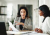 Strategy is Not Enough: Linda Grizely on the Behavioral Architecture Underlying Every Financial Decision Business women, Linda Grizely, documents or discussion with budget for financial planning or corporate insurance at office.