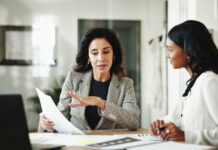 Business women, Linda Grizely, documents or discussion with budget for financial planning or corporate insurance at office.