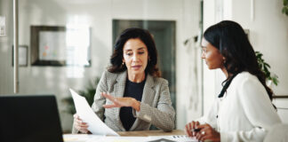 Business women, Linda Grizely, documents or discussion with budget for financial planning or corporate insurance at office.