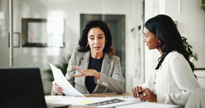 Business women, Linda Grizely, documents or discussion with budget for financial planning or corporate insurance at office.