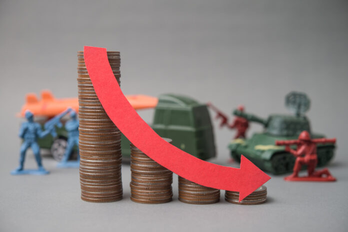 Red falling down red graph and stack coins with soldier fights, weapon war background. Red falling down red graph and stack coins with soldier fights, weapon war background. The global economic impact of the war, recession, energy crisis, oil price hike supply shortage and Effect of Iran war.