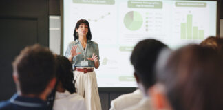 Presentation, screen and businesswoman in office for planning with finance graph, statistics or charts. Meeting, speech and female financial manager with information for investment pitch in workplace