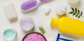 Overhead view pink salt with cosmetics products white background