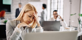 The Hidden Rebellion Against RTO and for Well-Being Stressed businesswoman holding her head in pain and having headache at work.