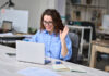 Happy young business woman employee, hr manager having remote online work hybrid meeting or distance job interview waving hand looking at laptop during virtual video conference call in office.
