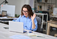 How A Major Hybrid Work Inquiry Should Change Washington Happy young business woman employee, hr manager having remote online work hybrid meeting or distance job interview waving hand looking at laptop during virtual video conference call in office.
