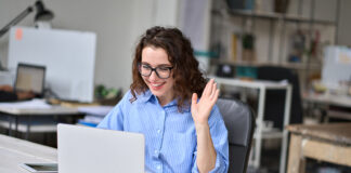 How A Major Hybrid Work Inquiry Should Change Washington Happy young business woman employee, hr manager having remote online work hybrid meeting or distance job interview waving hand looking at laptop during virtual video conference call in office.