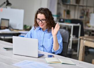 How A Major Hybrid Work Inquiry Should Change Washington Happy young business woman employee, hr manager having remote online work hybrid meeting or distance job interview waving hand looking at laptop during virtual video conference call in office.